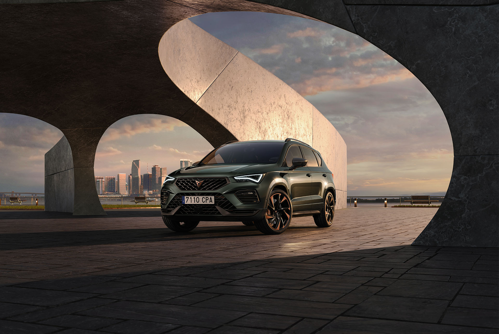 Front view of the CUPRA Ateca Tribe Edition showcasing its striking exterior in Dark Forest and Magic Black, set against an architectural backdrop. 